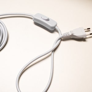 May include: White electrical cord with a white inline switch and a white three-prong plug.
