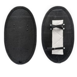 May include: A black oval shield with a leather strap and a white padded handle on the back.