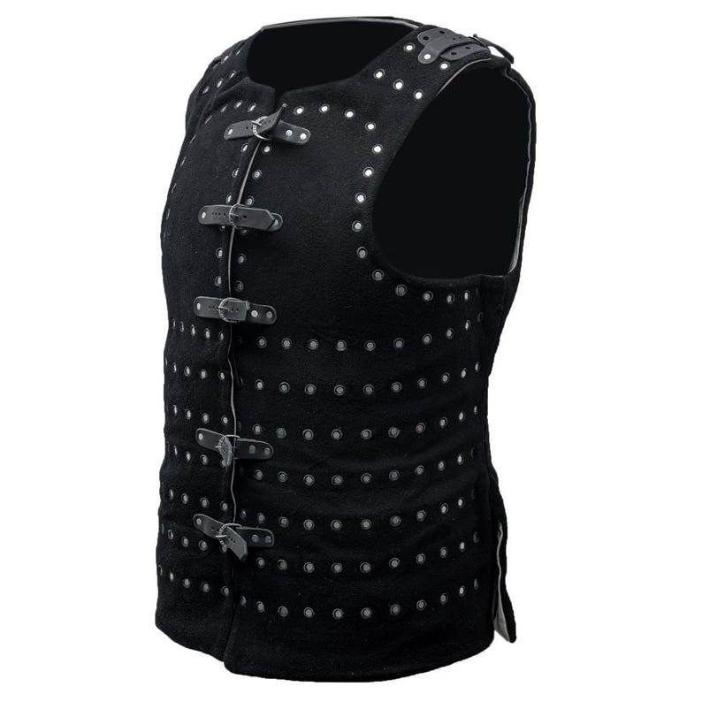 May include: A black sleeveless vest with a studded design and multiple buckles. The vest is made of a thick, textured fabric.
