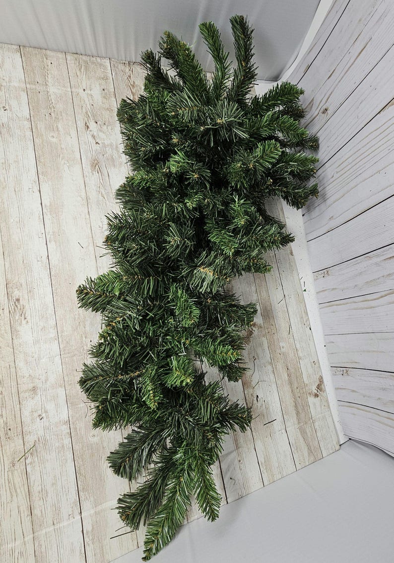 May include: A long, green garland of artificial pine branches, perfect for decorating for the holidays.