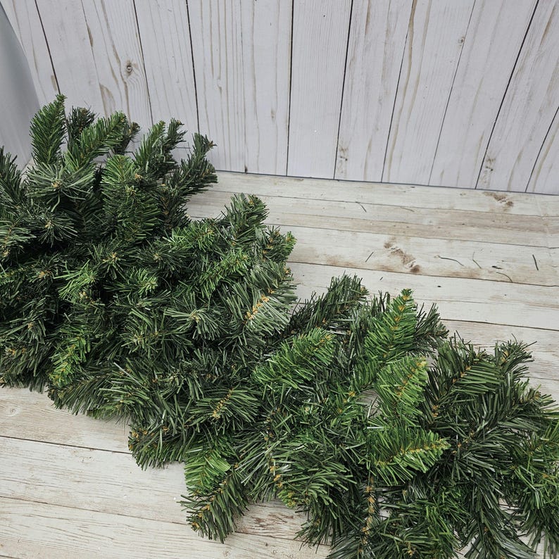 May include: Two bundles of artificial pine sprigs, perfect for crafting wreaths, garlands, or other holiday decor.