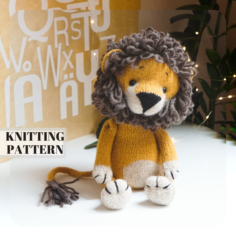 May include: Knitting pattern for a lion plush toy. The lion is sitting with its paws in front of it. It has a brown mane, a yellow body, and a white belly. The lion has black eyes and a black nose.