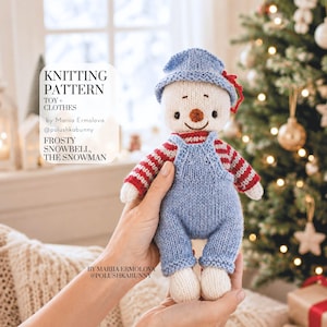 May include: A knitted snowman toy wearing a blue hat and blue overalls over a red and white striped sweater. The text reads: KNITTING PATTERN TOY + CLOTHES by Mariia Ermolova @polushkabunny FROSTY SNOWBELL, THE SNOWMAN. BY MARIIA ERMOLOVA @POLUSHKABUNNY.