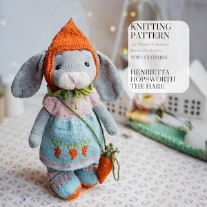 May include: A knitted gray bunny doll wearing an orange hat, a pink and blue dress with carrot details, and blue shoes. The doll has a green collar and a carrot-shaped purse. Text on the right reads "KNITTING PATTERN" and "HENRIETTA HOPSWORTH THE HARE."