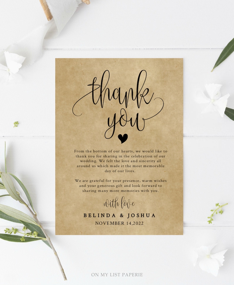 May include: A thank you card with a rustic brown background and black text. The card says "Thank you" with a small black heart. The text reads "From the bottom of our hearts, we would like to thank you for sharing in the celebration of our wedding. We felt the love and sincerity all around us which made it the most memorable day of our lives. We are grateful for your presence, warm wishes and your generous gift and look forward to sharing many more memories with you. With love, Belinda & Joshua, November 14, 2022. On My List Paperie."