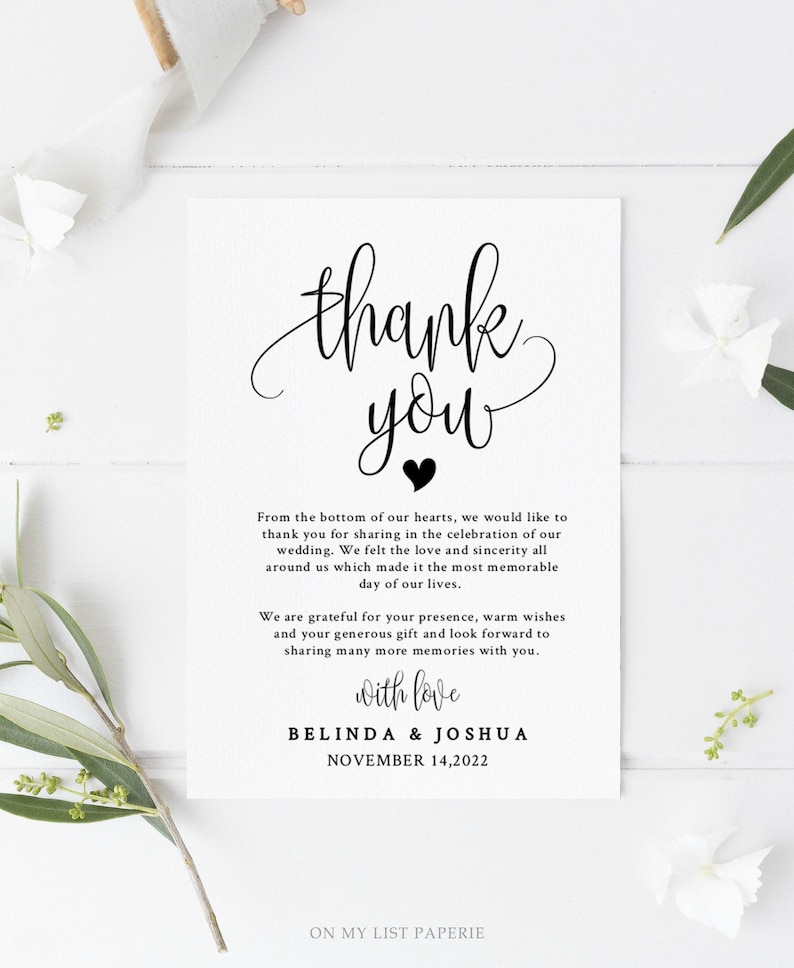 May include: A black and white thank you card with a handwritten thank you message and a small heart. The card reads "Thank you" with a heart symbol and "From the bottom of our hearts, we would like to thank you for sharing in the celebration of our wedding. We felt the love and sincerity all around us which made it the most memorable day of our lives. We are grateful for your presence, warm wishes and your generous gift and look forward to sharing many more memories with you. With love, Belinda & Joshua, November 14, 2022."