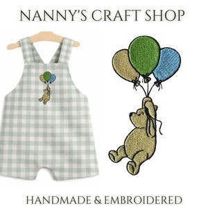 Pode incluir: Um macac&atilde;o de beb&ecirc; com um padr&atilde;o xadrez verde e branco, com um desenho bordado de um urso segurando bal&otilde;es. A imagem tamb&eacute;m mostra um urso bordado separado com bal&otilde;es. O texto diz "Nanny's Craft Shop" e "Handmade & Embroidered."