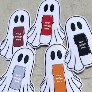 May include: Five die-cut stickers shaped like white ghosts with black oval eyes. Each ghost holds a different colored rectangular can—maroon, red, black, light gray, and orange—with the text Your design here printed on each can.