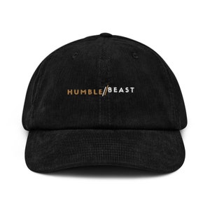 May include: Black corduroy baseball cap with white embroidered text "HUMBLE/BEAST" in a gold and white font.