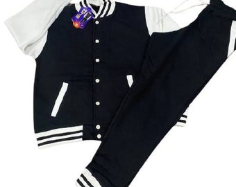 May include: A black and white varsity jacket with a button closure and matching black sweatpants. The jacket has white stripes on the sleeves and bottom hem. The sweatpants have white stripes on the bottom hem.