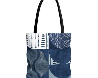 Puede incluir: Un bolso tote con asa negra y diseño geométrico. El diseño presenta un mosaico de patrones azules y blancos, incluyendo círculos, líneas y motivos florales. Es probable que el bolso esté hecho de tela.