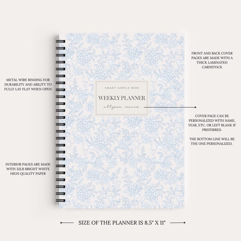 May include: A weekly planner measuring 8.5 inches by 11 inches with a light blue and white floral pattern. It features a black metal wire binding, a central label with the text SMART SIMPLE MOM WEEKLY PLANNER, and a space for personalization.
