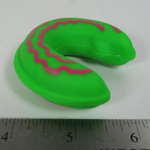 Puede incluir: Una almohada de viaje verde con un patrón de zigzag rosa.