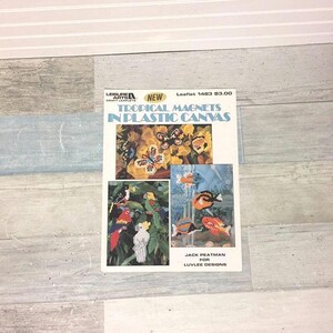 May include: A leaflet titled "Tropical Magnets in Plastic Canvas" featuring images of butterflies, parrots, and fish. The leaflet is labeled "New" and includes the text "Jack Peatman for Luvlee Designs."