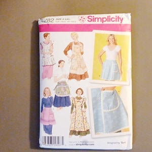 May include: A Simplicity sewing pattern envelope, number 4282, featuring illustrations of various apron styles. The white paper envelope displays multiple apron designs with floral and solid fabrics, along with a barcode and the Simplicity logo.