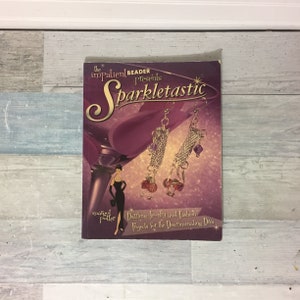 May include: A book titled "Sparkletastic" featuring jewelry and fashion projects. The cover shows a martini glass, a woman in a black dress, and dangling earrings with red and purple beads. The book is by Margot Poller.