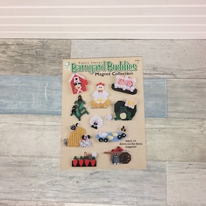 May include: A craft pattern titled "Barnyard Buddies Magnet Collection" featuring various farm animal designs. The designs include a red barn, a chicken, pigs, a Christmas tree, a sheep, a frog, a dog, ducks, carrots, and a cart.