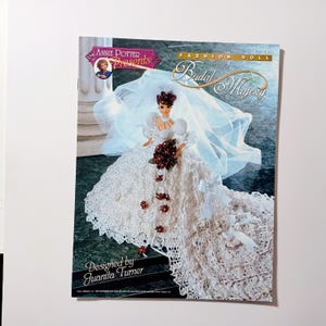 May include: A magazine cover featuring a fashion doll in a crochet wedding dress with a long train and veil. The cover reads "Fashion Doll Crochet Bridal Majesty" and "Designed by Juanita Turner."