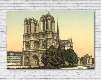 May include: A vintage postcard depicting Notre Dame Cathedral in Paris, France. The cathedral is a large, ornate structure with two tall towers and a pointed spire. The postcard is in color and shows the cathedral in a sunny day.