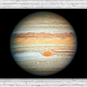 Puede incluir: Una imagen de primer plano de Júpiter, un gigante gaseoso con nubes giratorias en tonos marrones, naranjas y blancos. La Gran Mancha Roja del planeta es visible como un óvalo rojo-naranja.