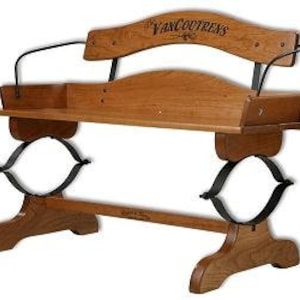 May include: A wooden bench with a curved back and a metal frame. The bench has a shelf underneath and the words "VanCoutrens" are engraved on the back.