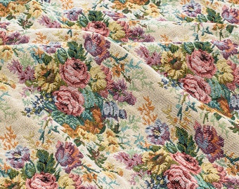 May include: A close-up of a beige fabric with a floral pattern. The fabric features a repeating pattern of pink, red, and green flowers. The fabric is textured and has a slightly raised surface.