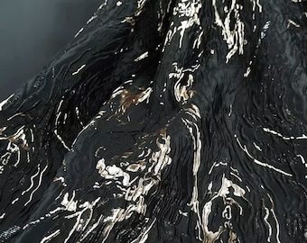 May include: Black fabric with a textured, wavy pattern and gold metallic accents.