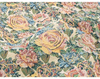 May include: A close-up of a fabric with a floral pattern. The fabric is a cream color with a variety of flowers in shades of yellow, pink, blue, and green. The flowers are woven into the fabric, creating a textured look.