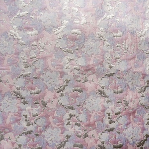 Puede incluir: Primer plano de una tela rosa y plateada con un patrón abstracto texturizado. La tela tiene un brillo sutil y una sensación suave y lujosa.
