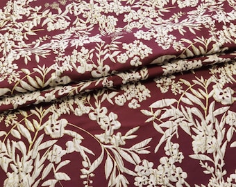 May include: Burgundy fabric with a white floral pattern. The fabric has a raised texture and a subtle sheen.