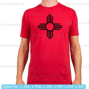 May include: A red t-shirt with a black graphic of the Zia symbol, a traditional symbol of the Pueblo people of New Mexico.