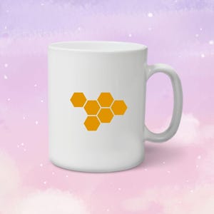 May include: White ceramic mug with a honeycomb design in orange. The mug has a handle on the right side.