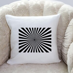 K&ouml;nnte beinhalten: Ein wei&szlig;es Kissen mit einem schwarz-wei&szlig;en Sonnenstrahlen-Design. Das Design ist mittig auf dem Kissen platziert und hat einen schwarzen Kreis in der Mitte.