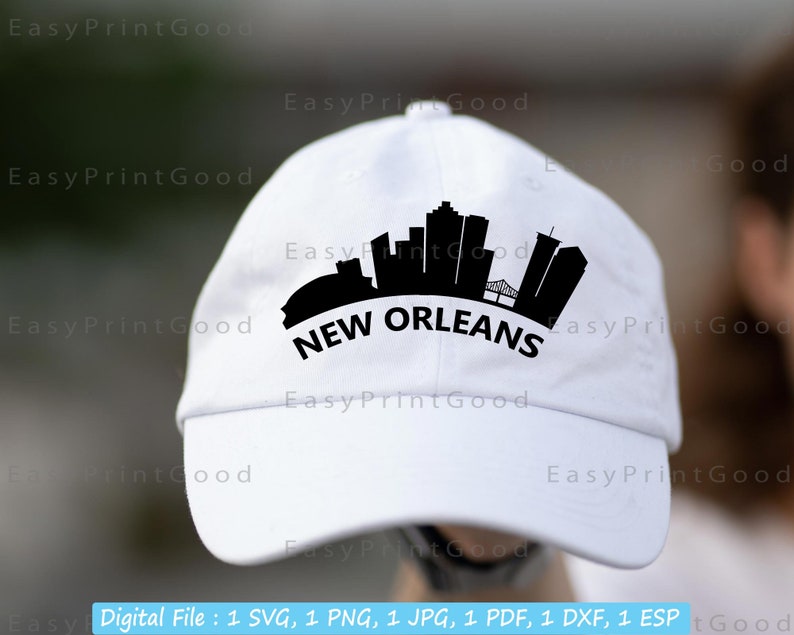 May include: White baseball cap with a black silhouette of the New Orleans skyline and the text "NEW ORLEANS" in black.