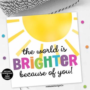 Puede incluir: Tarjeta imprimible con un sol amarillo y el texto "el mundo es MÁS BRILLANTE por ti!" en colores arcoíris. La tarjeta tiene un fondo blanco y un borde negro.