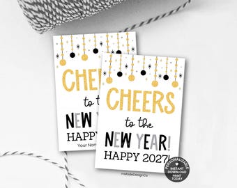 Può includere: Due etichette rettangolari in carta con testo in glitter dorato che recita CHEERS to the NEW YEAR! HAPPY 2027! Il design include ornamenti circolari dorati e neri appesi con accenti a stella su sfondo bianco. Un piccolo badge circolare riporta INSTANT DOWNLOAD PRINT TODAY.