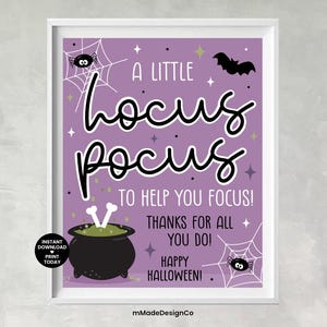 May include: A framed Halloween-themed print with a purple background. The text reads "A Little Hocus Pocus To Help You Focus!" with a cauldron, spiderwebs, and a bat graphic. The print is in a white frame.