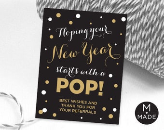 May include: Black and gold New Year's Eve party sign with white polka dots and the text "Hoping your New Year starts with a POP!" and "Best wishes and thank you for your referrals".