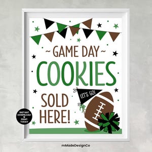 Peut inclure: Impression encadrée avec le texte "GAME DAY COOKIES SOLD HERE!" en vert et marron. L'image comprend un ballon de football, des fanions et des étoiles, avec les mots "LET'S GO!" sur un drapeau. Un petit cercle dit "TÉLÉCHARGEMENT INSTANTANÉ IMPRIMER AUJOURD'HUI".
