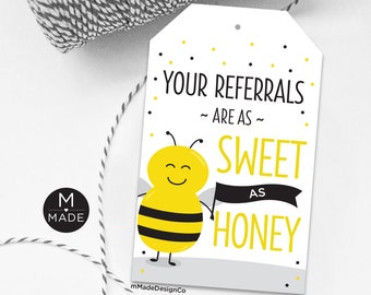 Peut inclure: Une étiquette blanche avec une illustration d'abeille noire et jaune. L'étiquette dit "Vos références sont aussi douces que le miel".
