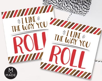 May include: Two white cards with the text "I LIKE THE WAY YOU ROLL" in red and brown. The cards have a striped border in red, brown, and white. A black and white string is in the background.