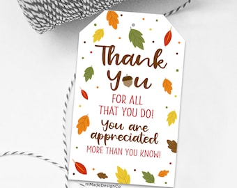May include: A white tag with the words "Thank You" in brown script, accompanied by the text "FOR ALL THAT YOU DO! You are appreciated MORE THAN YOU KNOW!" Colorful leaves and dots decorate the tag, perfect for expressing gratitude.