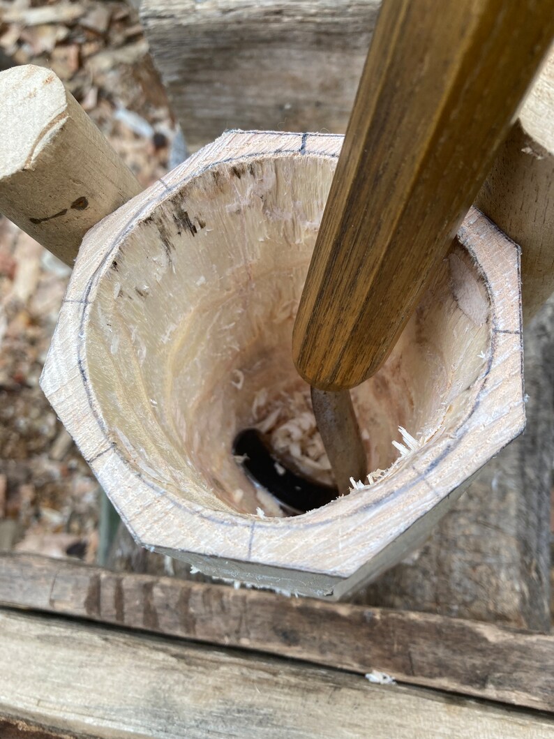 Puede incluir: Un cuenco de madera que se est&aacute; tallando con un cincel. El cuenco est&aacute; hecho de madera clara y tiene una forma redonda. El cincel est&aacute; hecho de madera oscura y tiene una hoja afilada.