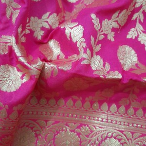 Puede incluir: Tela rosa con un patr&oacute;n floral dorado. La tela tiene un borde con un dise&ntilde;o dorado m&aacute;s intrincado.