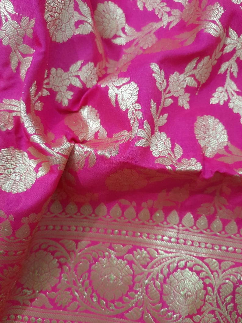 Puede incluir: Tela rosa con un patr&oacute;n floral dorado. La tela tiene un borde con un dise&ntilde;o dorado m&aacute;s intrincado.