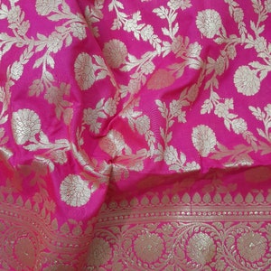 Puede incluir: Tela rosa con un patr&oacute;n floral dorado. La tela tiene un borde con un dise&ntilde;o floral m&aacute;s intrincado.