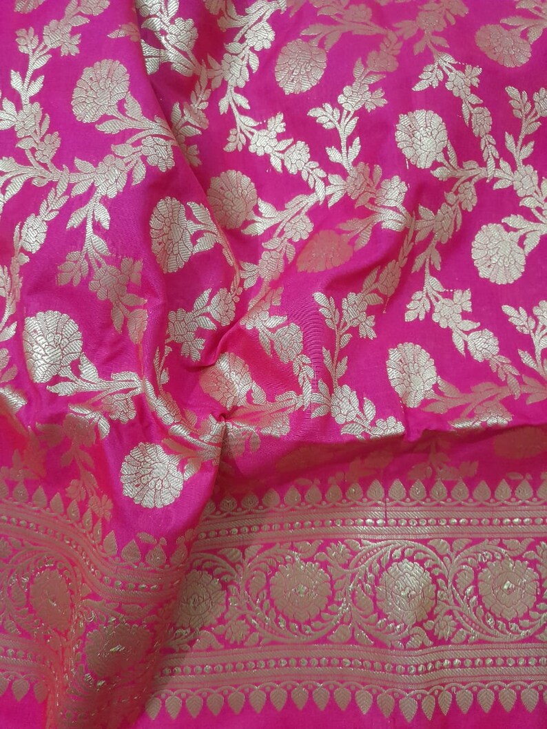 Puede incluir: Tela rosa con un patr&oacute;n floral dorado. La tela tiene un borde con un dise&ntilde;o floral m&aacute;s intrincado.