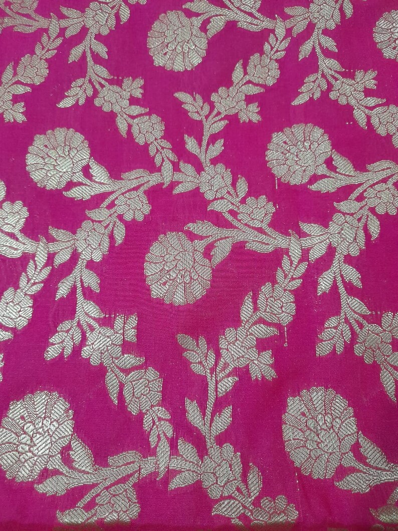 Puede incluir: Tela rosa con un patr&oacute;n floral plateado. Las flores son intrincadas y detalladas, y la tela tiene un brillo sutil.