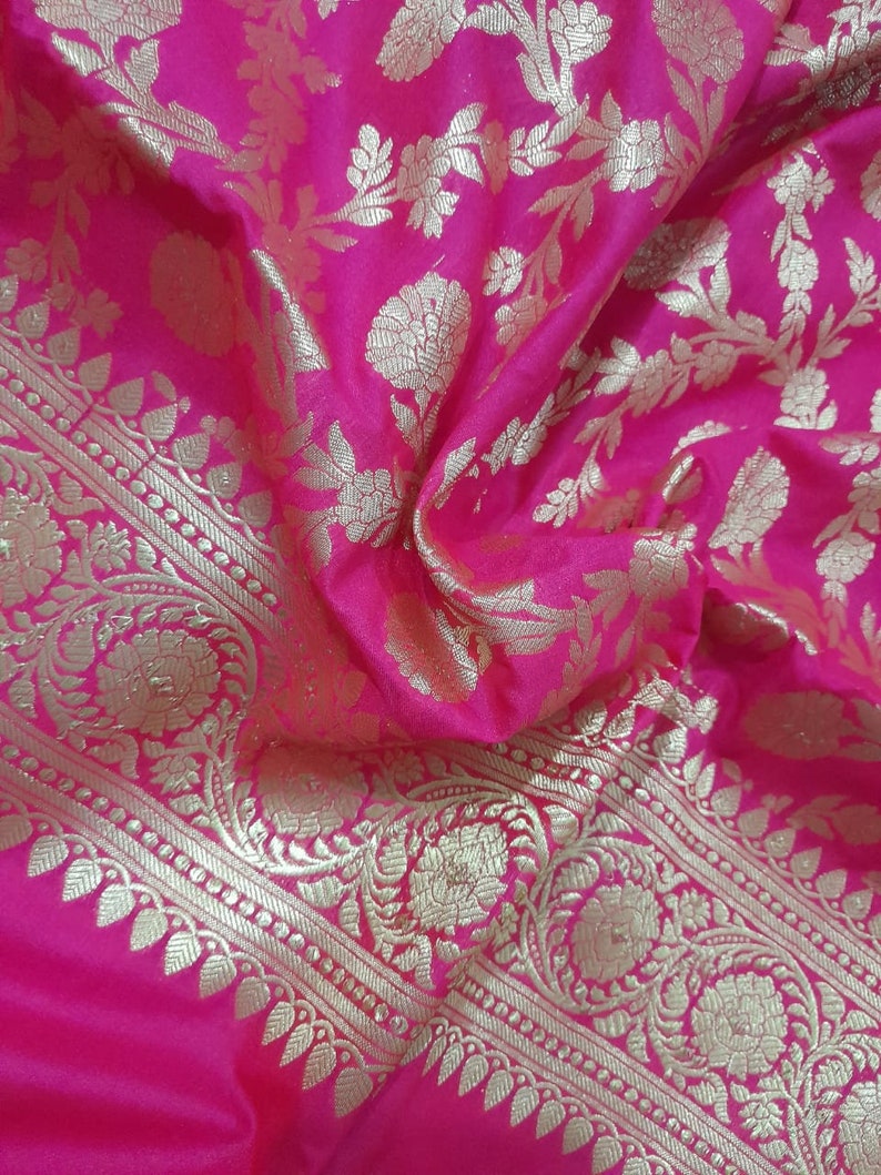 Puede incluir: Tela rosa con un patr&oacute;n floral dorado. La tela tiene un borde con un dise&ntilde;o dorado m&aacute;s intrincado.