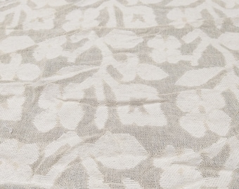 May include: White fabric with a woven pattern of repeating geometric shapes. The fabric is textured and has a slightly wrinkled appearance.